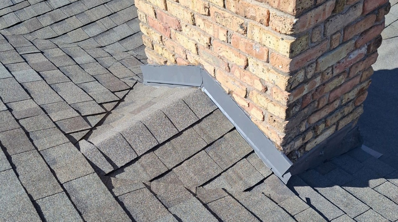 Chimney flashing repair on an asphalt shingle roof in Dallas