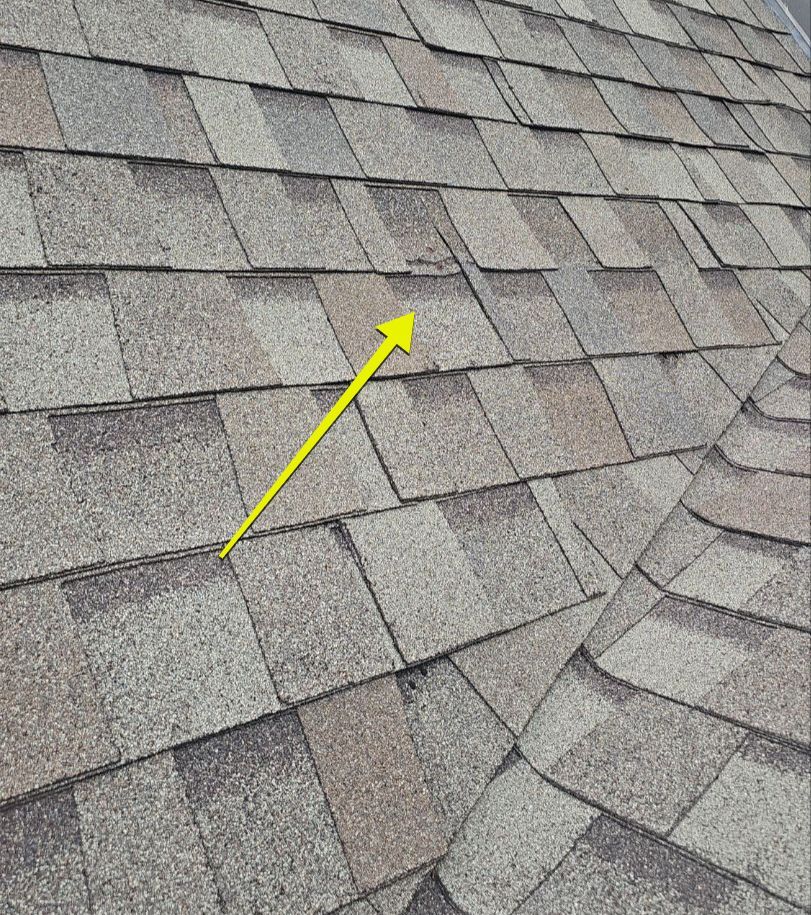 Torn shingle and exposed fastener in a leaking roof valley in Lakewood Dallas 75214