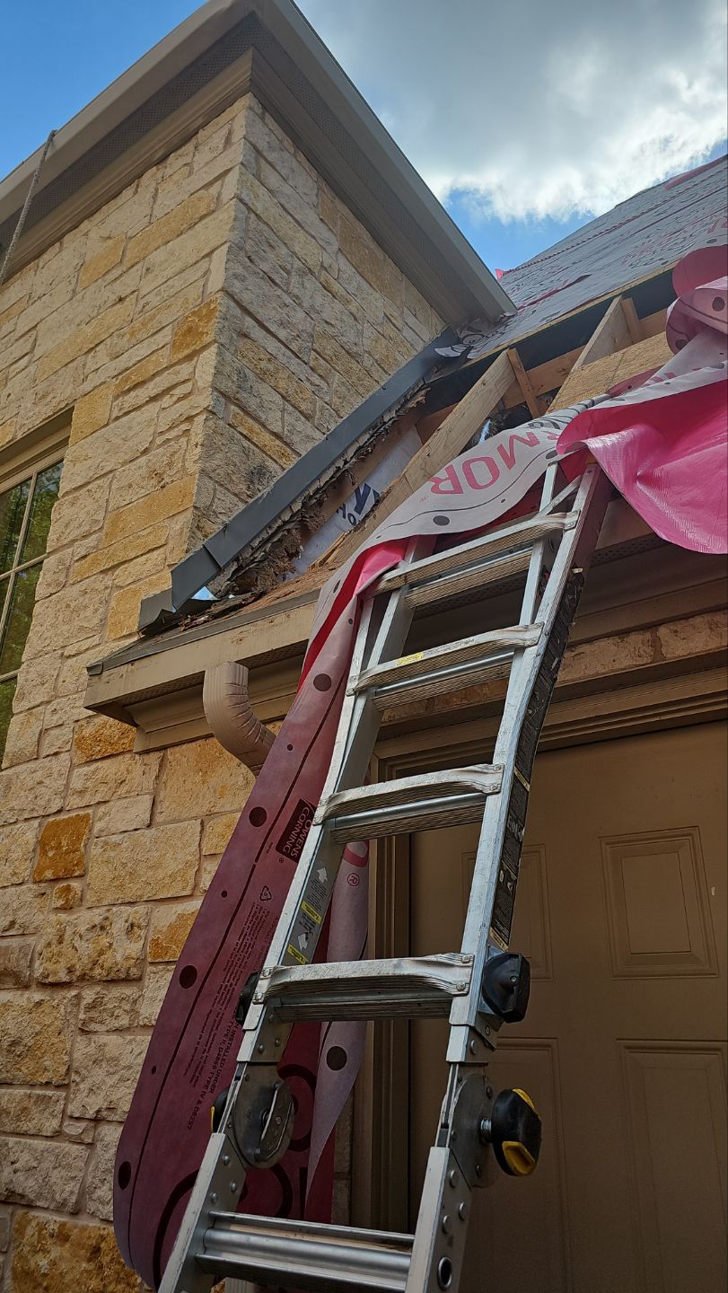Damaged roof decking removed beside a chimney during a Preston Hollow roof replacement in Dallas.