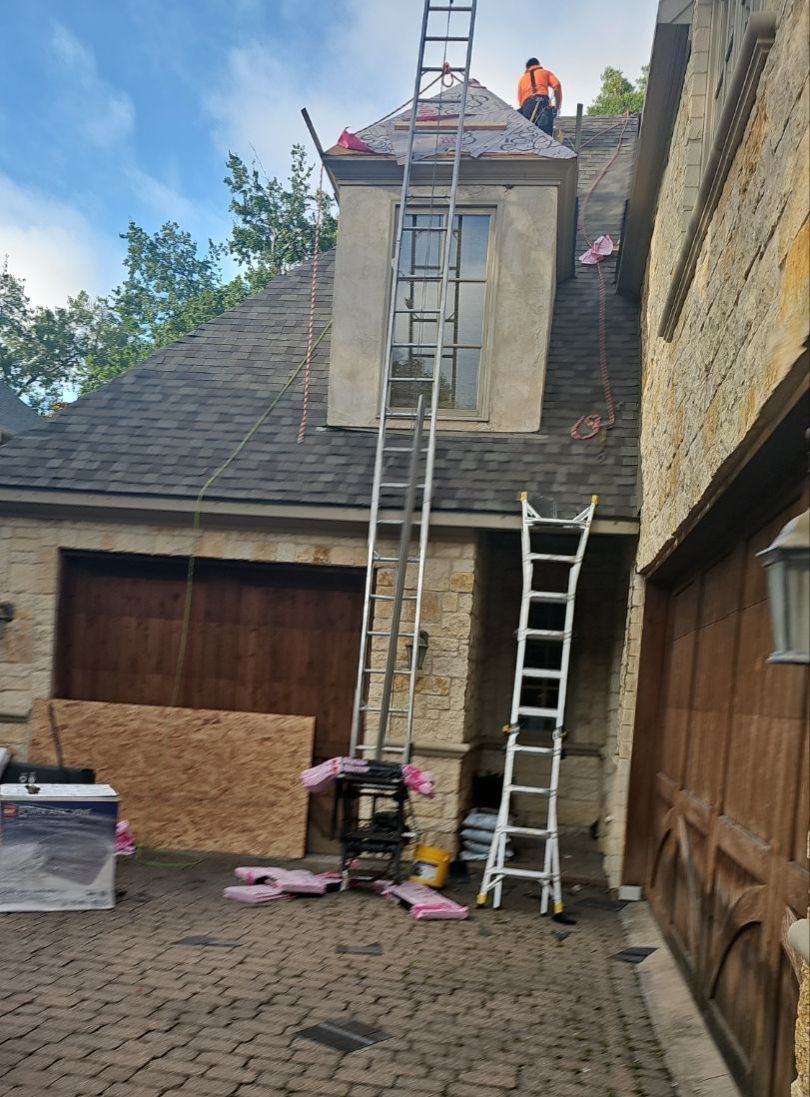Ladders set up for work on a steep, complex Preston Hollow roof replacement in Dallas.