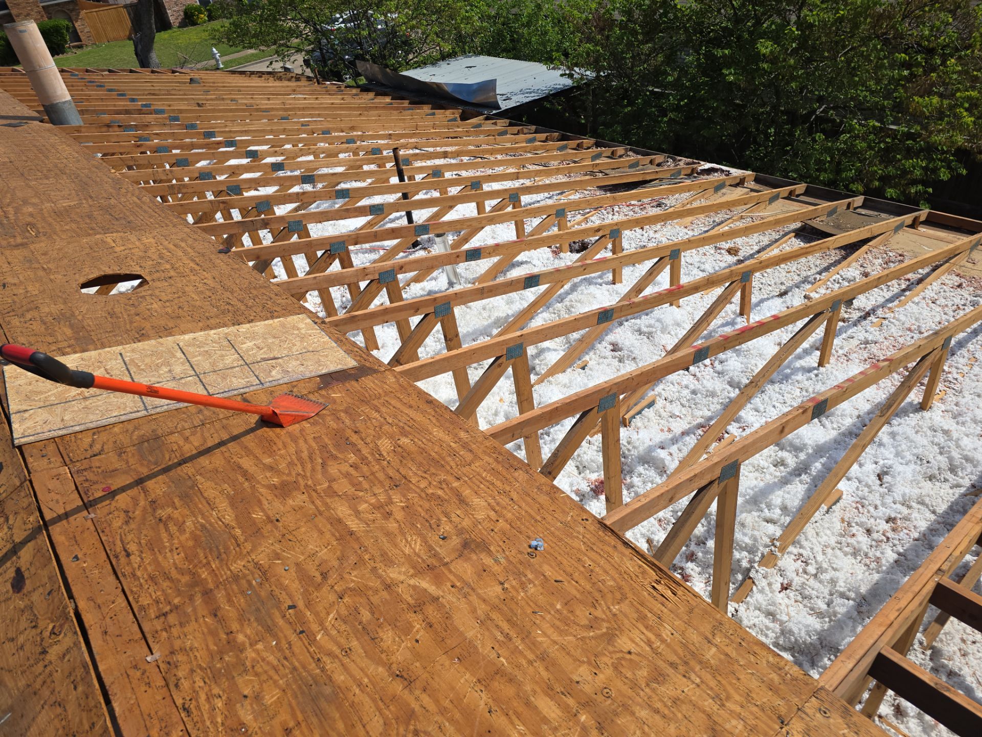 Roof decking replacement in progress on Garland home with rafters exposed