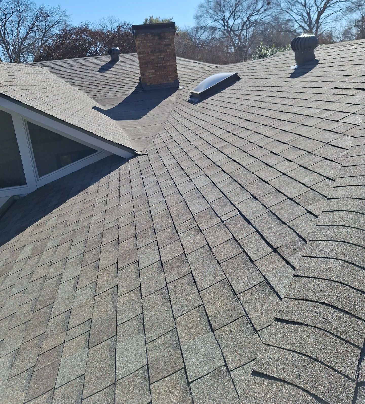 Hail-impacted asphalt shingle roof in Dallas being evaluated for impact-resistant replacement