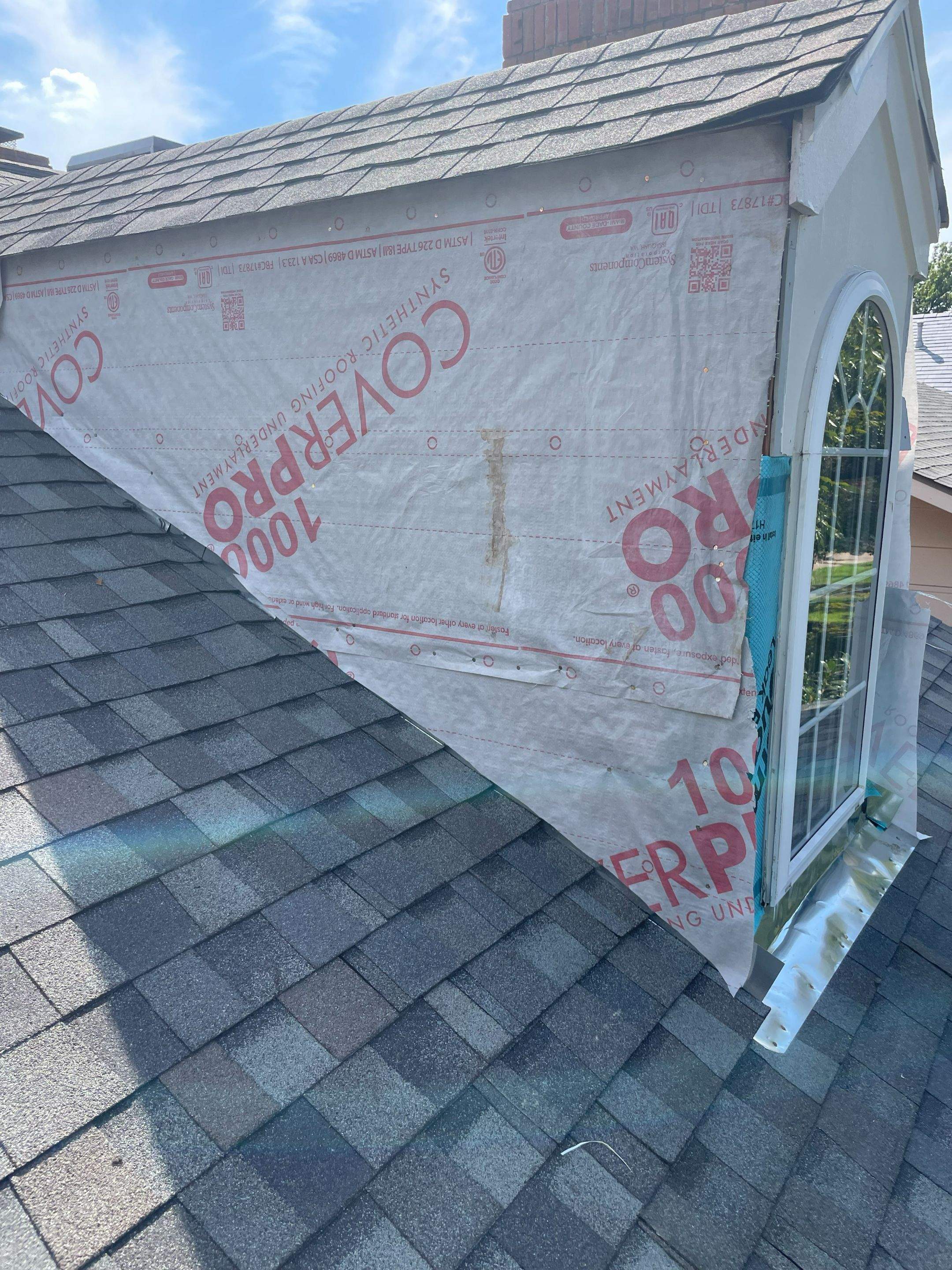 Dormer sidewall with weather-resistant barrier over new wall sheathing during a Highland Park roof and siding repair.
