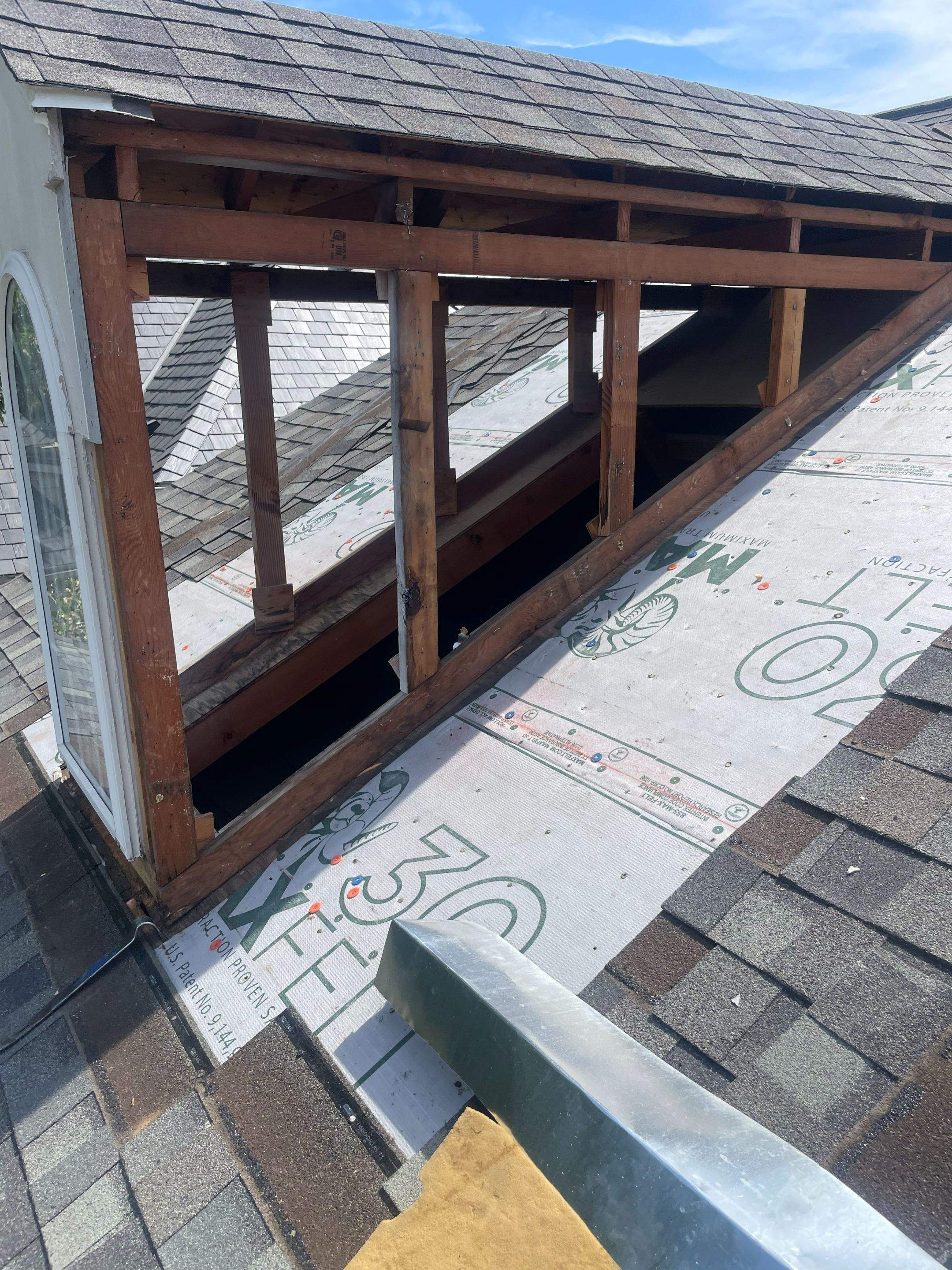 Exposed dormer wall framing during roof flashing and siding repairs on a Highland Park home near SMU.