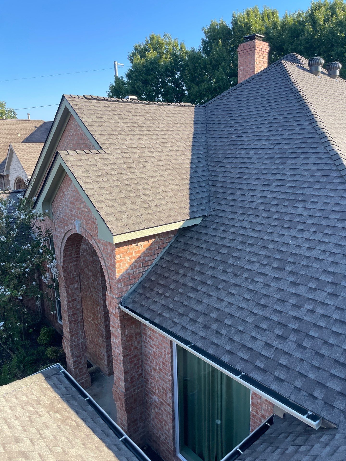 GAF Timberline HDZ Weathered Wood roof replacement on a home in Garland's Firewheel neighborhood, showing steep rooflines and architectural details.