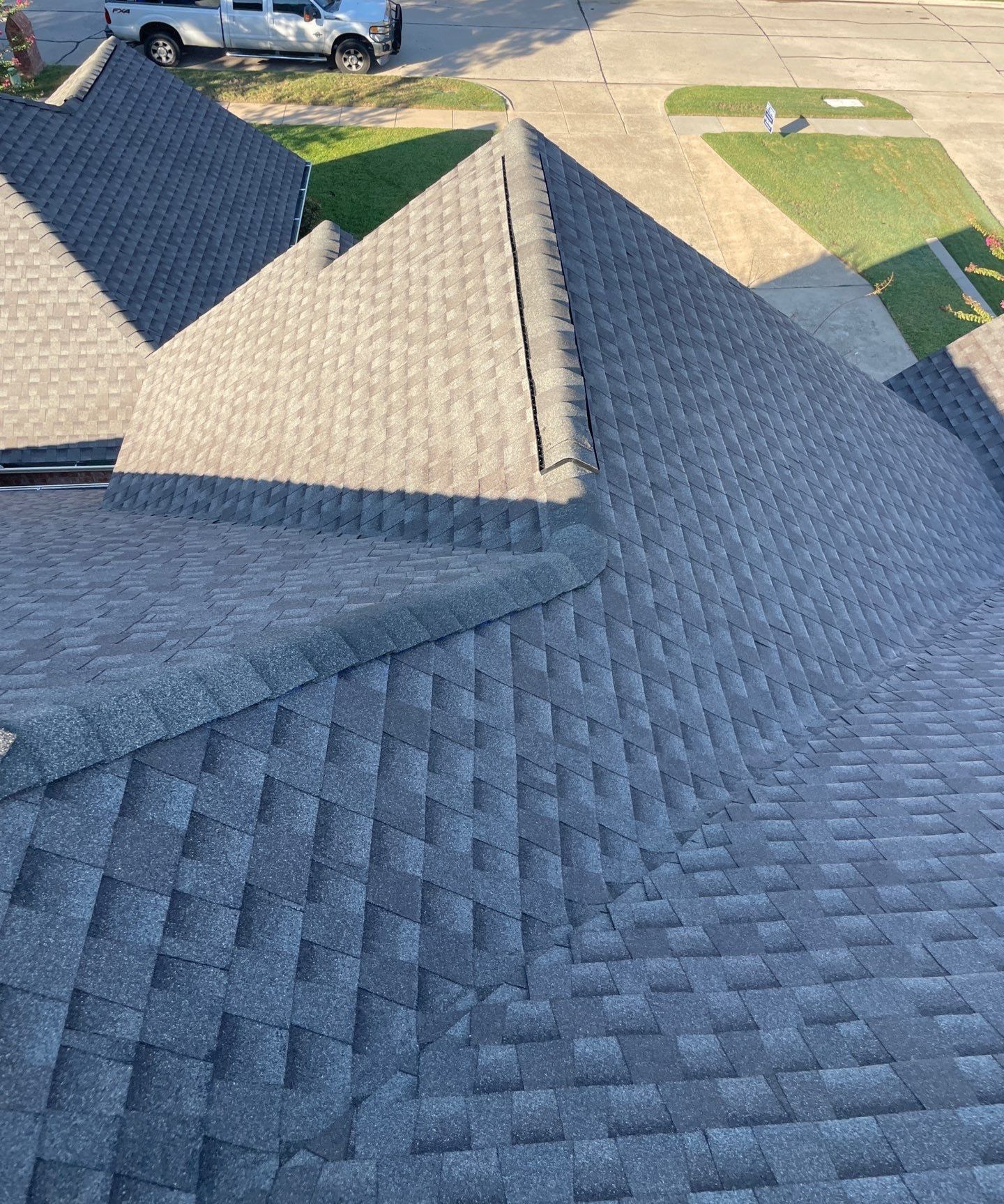 Steep GAF Timberline HDZ shingle roof showing intersecting hips and valleys on a home in Firewheel, Garland, Texas.