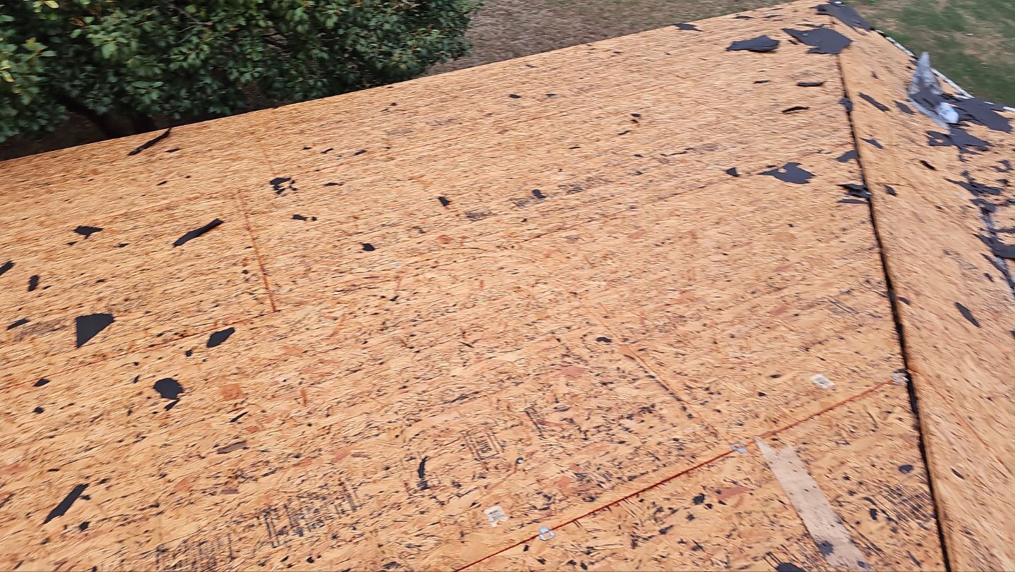 Exposed OSB roof decking after removal of old shingles and multiple layers of felt on an East Dallas home.